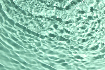 Rippled surface of clear water on aquamarine background, closeup