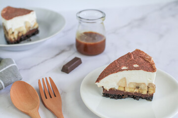 Homemade Banoffee cake made from bananas, whipped cream and a thick caramel sauce on table.