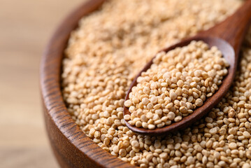 Brown quinoa seed in wooden bowl with spoon, Healthy food ingredient