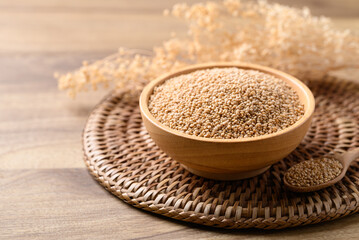 Brown quinoa seed in wooden bowl with spoon, Healthy food ingredient