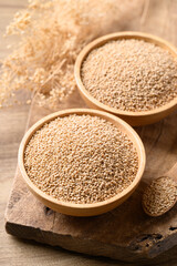Brown quinoa seed in bowl with spoon on wooden background, Healthy food ingredient