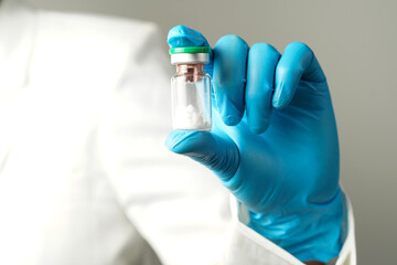 Fototapeta premium virus vaccine bottle for injection in hand of doctor or Technician scientist