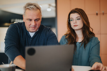 Senior businessman and young female colleague working together in office.
