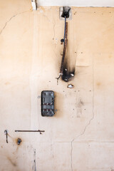Old Grunge Broken Metal Electrical Box Hanging On Cracked Beige Concrete Wall