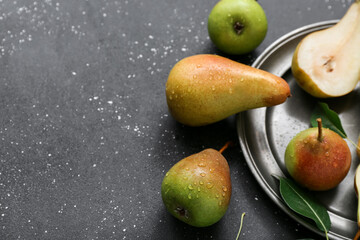 Plate with ripe pears on black table, closeup