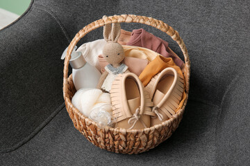 Gift basket for baby on armchair in room, closeup