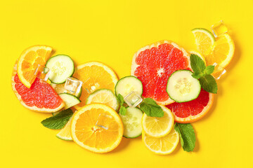 Composition with ice cubes and fresh ingredients for lemonade on yellow background