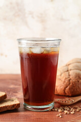 Glass of tasty kvass on table