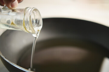  Pouring vegetable oil into frying pan.