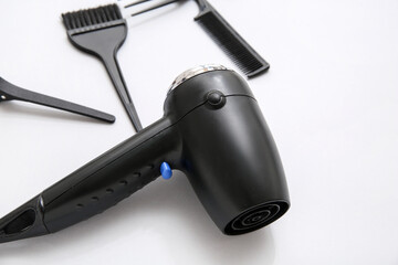 Hair dryer, brush and combs on light background