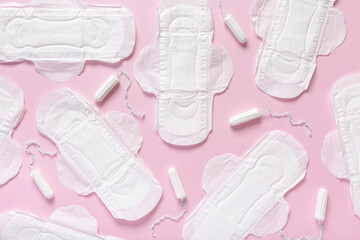 Menstrual pads and tampons on pink background
