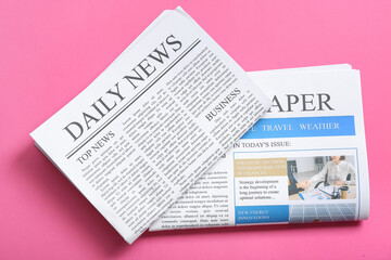 Different newspapers on pink background