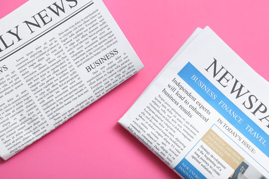 Different newspapers on pink background