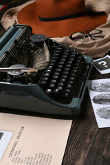 Retro typewriter, criminal files and clothes on wooden table