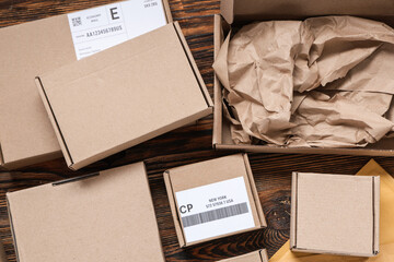 Cardboard packages with labels on wooden table, closeup