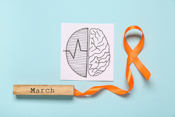 Paper brain with word MARCH and orange ribbon on blue background. Multiple Sclerosis Awareness Month