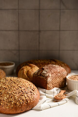 Loaves of fresh bread and buns against grey tile wall