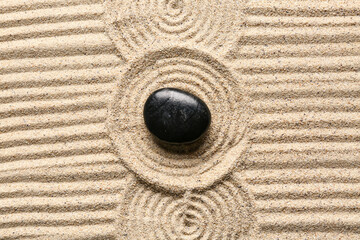Black stone on sand with pattern. Zen concept