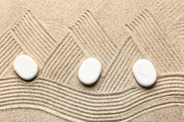 Spa stones on sand with pattern