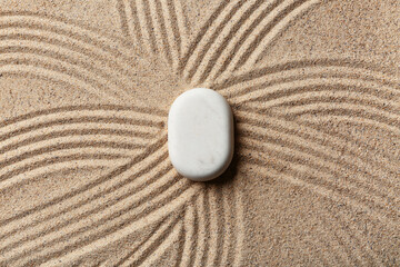 Spa stone on light sand with lines. Zen concept