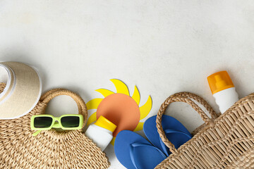 Bottles of sun protection cream and beach accessories on white background