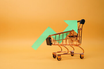 Green arrow of a chart on shopping trolley. Crisis and rising commodity prices concept.