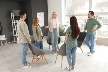 Female psychologist with people at group therapy session