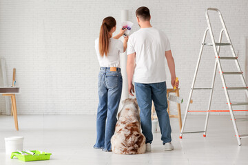Young couple with cute dog and palette samples planning design of their new home