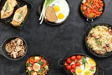 Frame made of different dishes on dark background