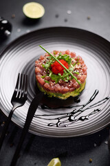 Tuna and avocado tartare on a dark ceramic plate