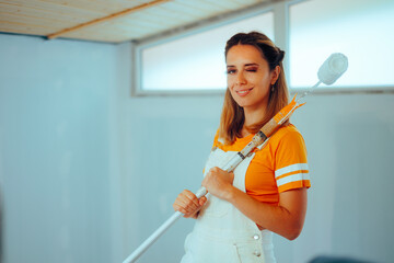 Happy Woman with Paint Roller Ready to make Home Renovation. Cheerful girl trying to renovate her...