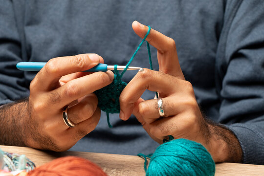 manos morenas de hombre tejiendo, roles de genero