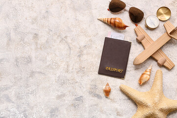 Composition with passport, sunglasses, wooden plane and seashells on grunge background