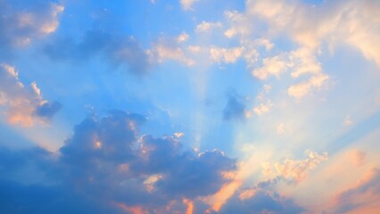 A beautiful sky with scattered clouds illuminated by the setting sun. The clouds display warm hues...