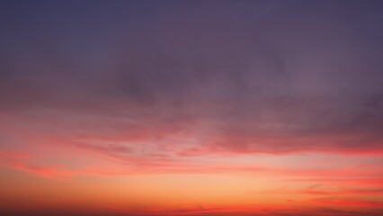 A vivid sunset with a sky transitioning from deep purple at the top to warm shades of pink and...