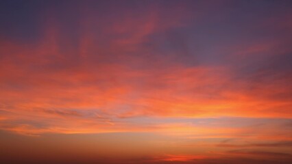 A stunning sunrise with the sky painted in vibrant hues of orange, pink, and purple. The gradient transitions smoothly from the intense colors near the horizon to a darker. Sunrise sky background.
