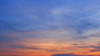 A serene sunrise with a sky transitioning from deep blue at the top to warm orange and pink tones...