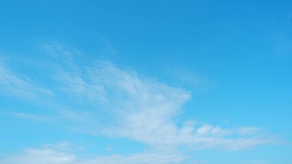 A vibrant blue sky dotted with scattered, fluffy white clouds. The contrast between the clear sky...