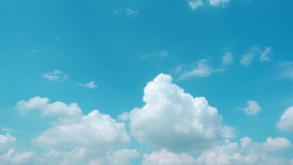 A bright blue sky with large, billowing white clouds. The clouds are thick and fluffy, creating a...