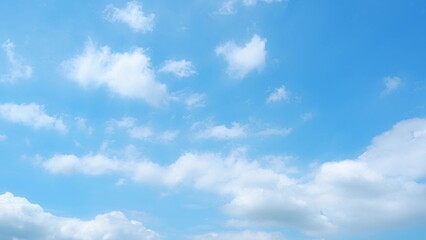 A serene blue sky dotted with fluffy white clouds. The clouds vary in size and are scattered across the sky, creating a soft, tranquil atmosphere against the bright blue background. Nature background.