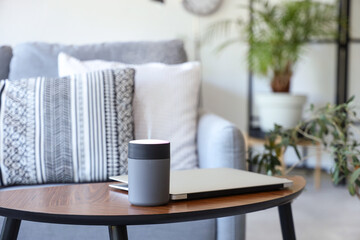 Air humidifier with laptop on coffee table in living room, closeup