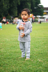 child drinking water from plastic bottle. water shortage problem on earth concept. water shortage problem lifestyle on earth concept. kid drinks water in nature from a bottle glare of the sun summer
