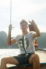 Rod, fish and fisherman in boat by sea on adventure, weekend holiday and vacation in Thailand....