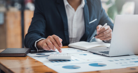 Businessman using calculator and laptop for financial analysis and investment planning....