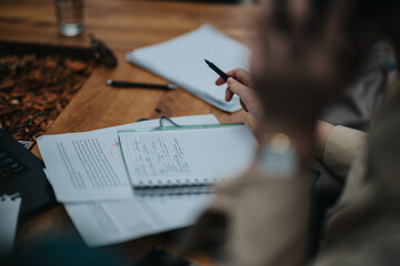 Close-up of business professional's hands writing on paper, with focus on planning and execution in...