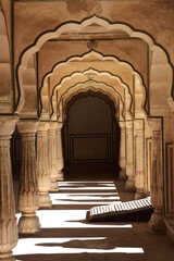 Shadows of the peoples in different acts lie on the balcony floor of India's Mughal architecture...