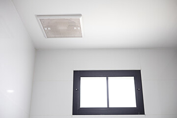 The exhaust fan is installed on the ceiling near the skylight.
