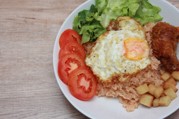 Fried rice with tomato sauce Or as we call it American fried rice Served with fried eggs, fried chicken, fresh stir-fry, and fried bread.