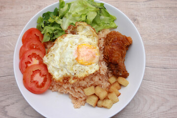 Fried rice with tomato sauce Or as we call it American fried rice Served with fried eggs, fried chicken, fresh stir-fry, and fried bread.