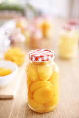 Kitchen, jar and peach on table, vegan and fruit for nutrition, healthy and glass on wood and protein. Home, countertop and preserved for diet, vitamin c and breakfast in morning, snack and food